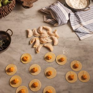 Creating schlutzkrapfen - filled pasta - with pumpkin filling on the pasta discs.