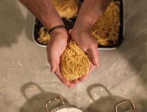 Uncooked spaghetti held in two hands.