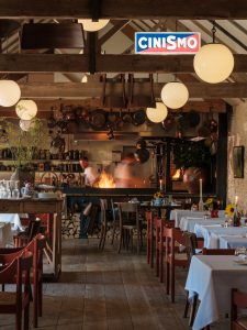 The interior of Da Costa looking towards the fire with flames in front of the chefs.
