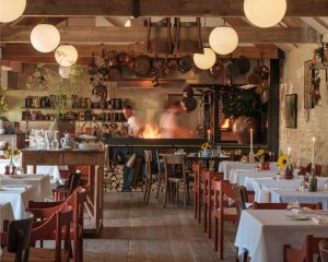 The interior of Da Costa looking towards the fire with flames in front of the chefs.