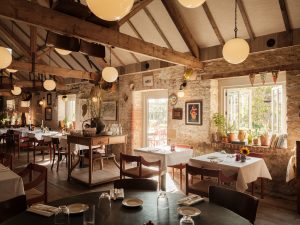 The interior of the Da Costa restaurant, showing the tables and sun streaming in through the windows.