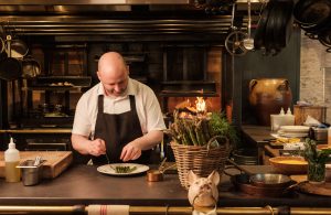 Asparagus being plated in front of a fire.