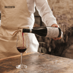 Da Costa waiter pouring a glass of red wine.