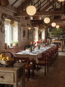 Da Costa tables set for an event with a long table laid up for dinner and lemons in a basket in the foreground.