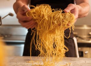 Spaghetti being tossed in flour.