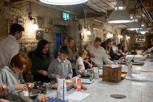 Chef helping children with pasta making