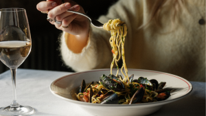 Spaghetti dish with mussels and glass of wine