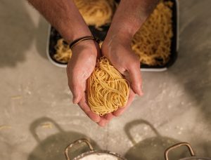 Uncooked spaghetti held in two hands.