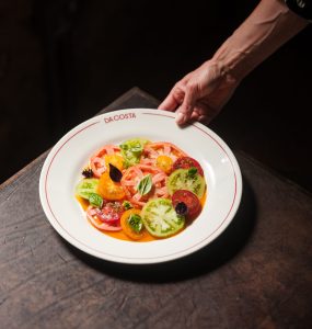 A white plate of tomatoes of different varieties